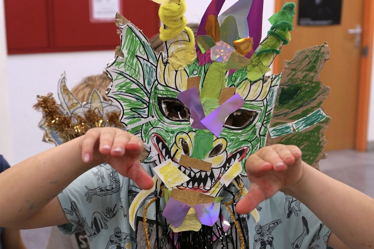 Ein Kind mit einer bunten Maske auf dem Kopf