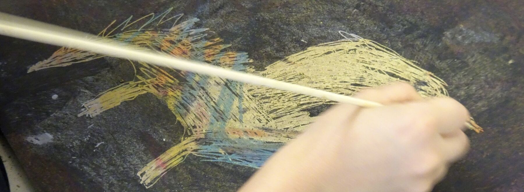 eine Kinderhand zeichnet ein Tier
