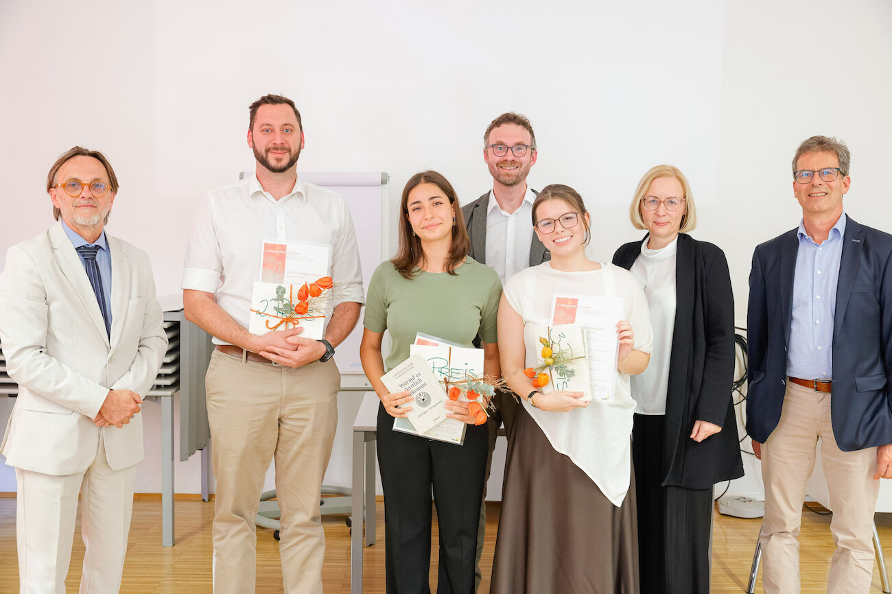 Gruppenbild: 3 Preisträger*innen mit Veranstalter*innen im Seminarraum