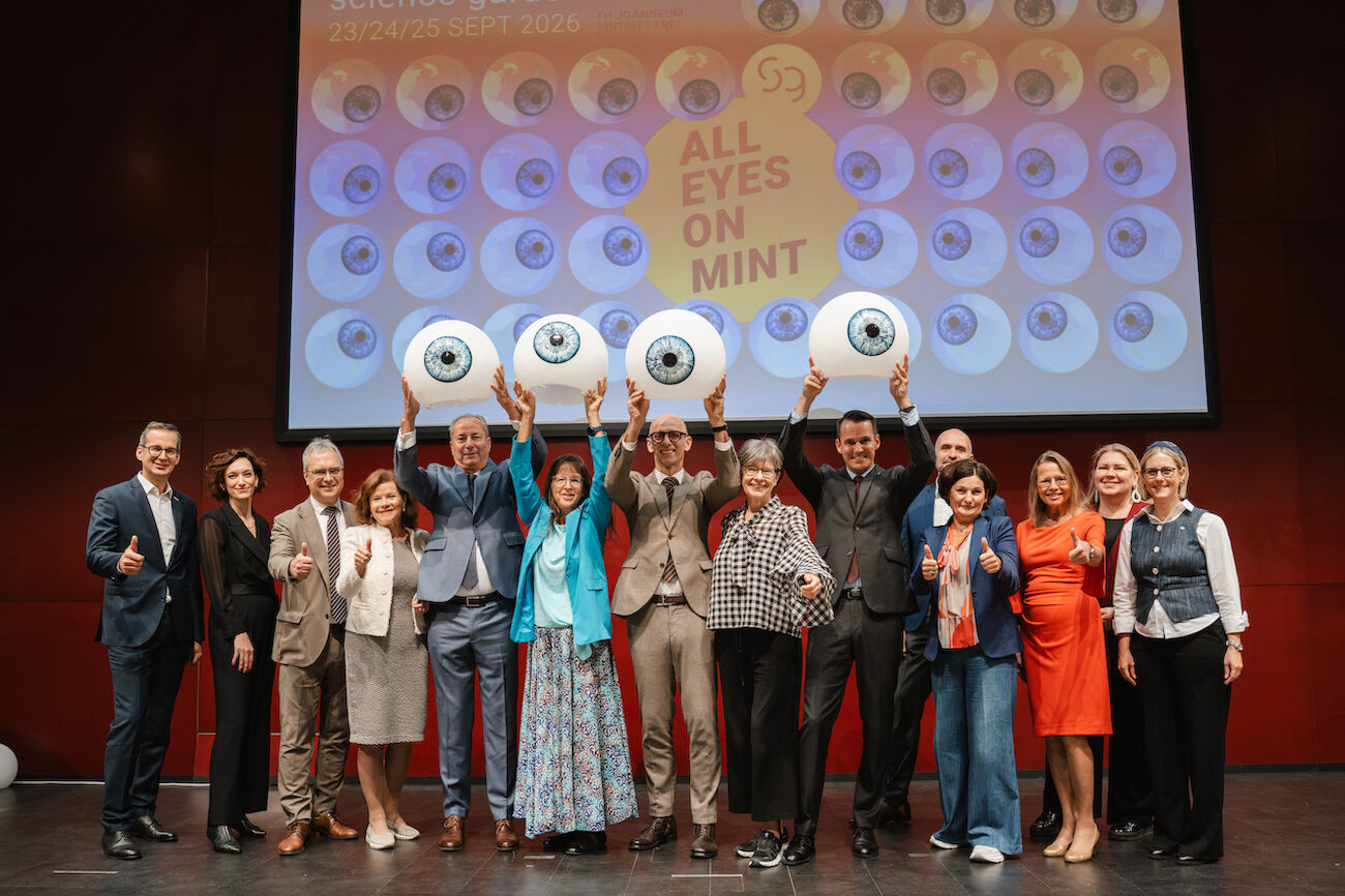 Gruppenbild: Verantwortliche MINT Festival im Festsaal mit dekorativen großen Augen in den Händen haltend
