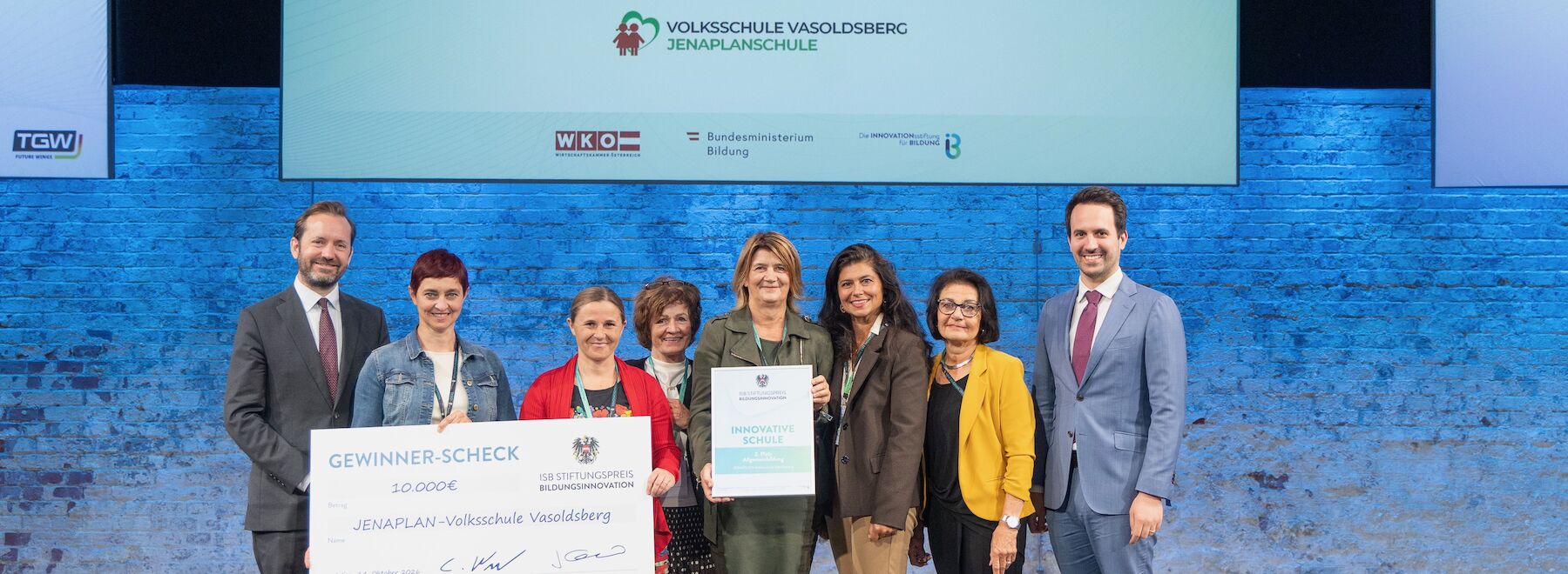 Gruppenbild: Preisverleihung auf dem Podium der Veranstaltungshalle