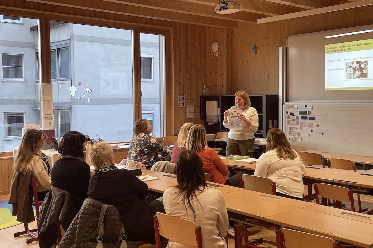 Teilnehmende und eine Lehrende der Fortbildung in einer Volksschulklasse