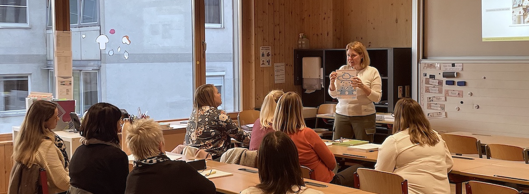Teilnehmende und eine Lehrende der Fortbildung in einer Volksschulklasse