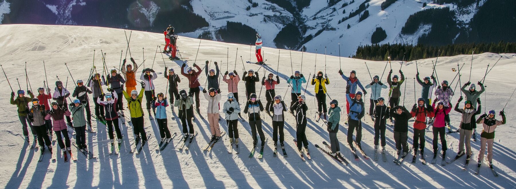 Gruppenbild der Wintersportwoche - Skifahrer und Skifahrerinnen auf dem Berg
