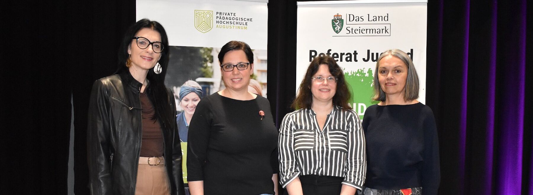Gruppenbild: Lehrende und Organisatorinnen der Veranstaltung auf dem Podium